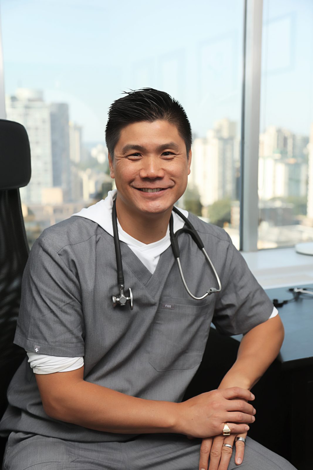 Dr. Marr seated, smiling, skyline behind